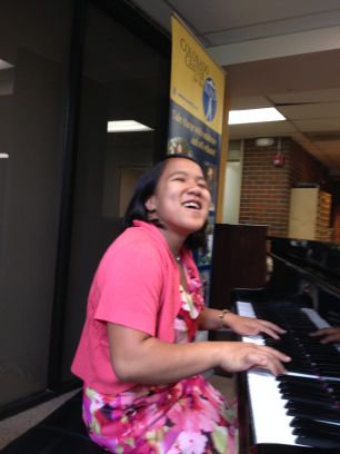 Annalyn seated at the piano in the Center's lobby