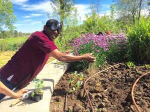 Man wearing sleepshades breaks clods of soil between his hands