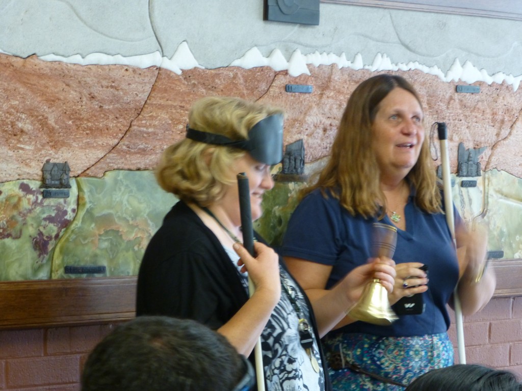 Smiling woman rings her hand bell vigorously