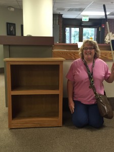 student stands beside her handsome 3-shelf bookshelf