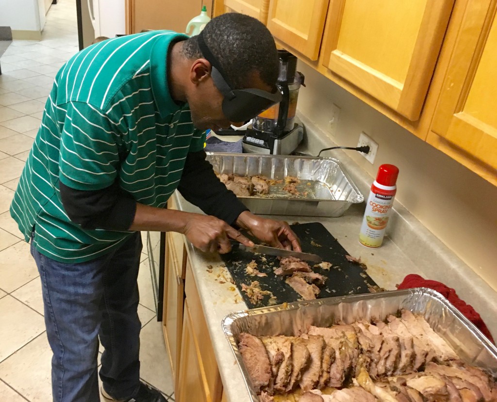 Man skillfully slices a large roast.