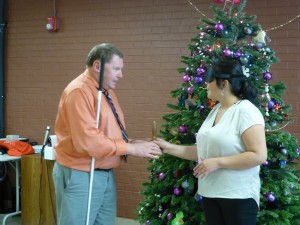 A man presents the bell to a young woman