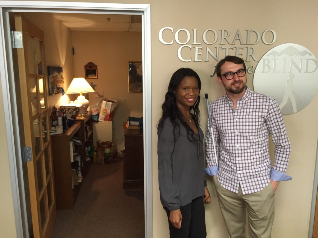 a man and woman stand before the tactile image of the cCB logo in our lobby