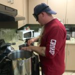 Daniel B. working two large pots on the stove preparing for his mini meal