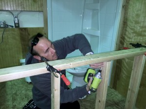 James uses a cordless drill to attach a stud in home maintenance class