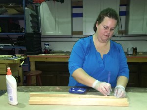 a woman applies glue to her wood project