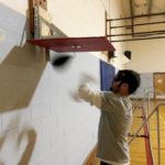 Marcus with blurred rotating fists as he hits the speed bag in rapid succession