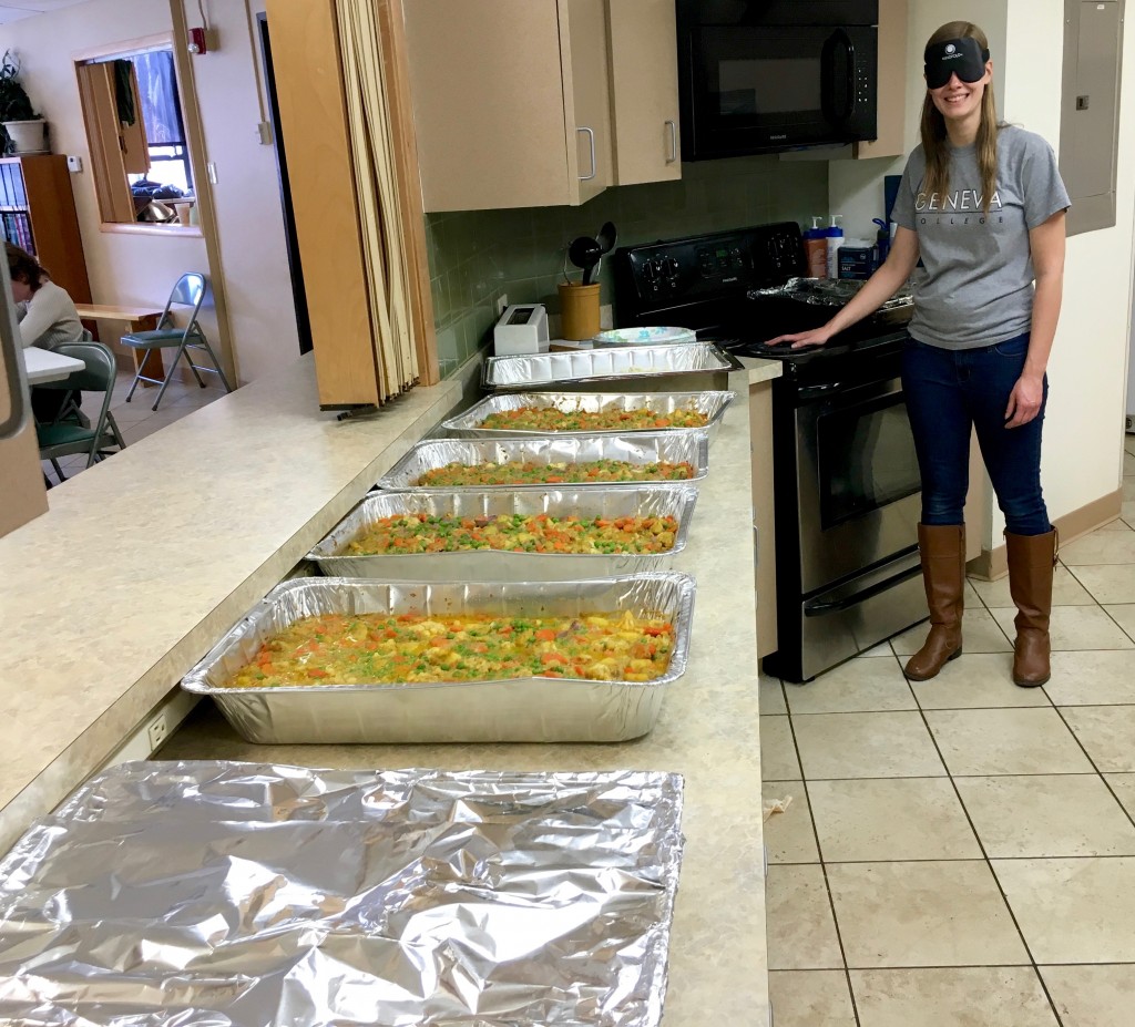 Tabea stands at the end of a long row of food ready to searve at her grad meal