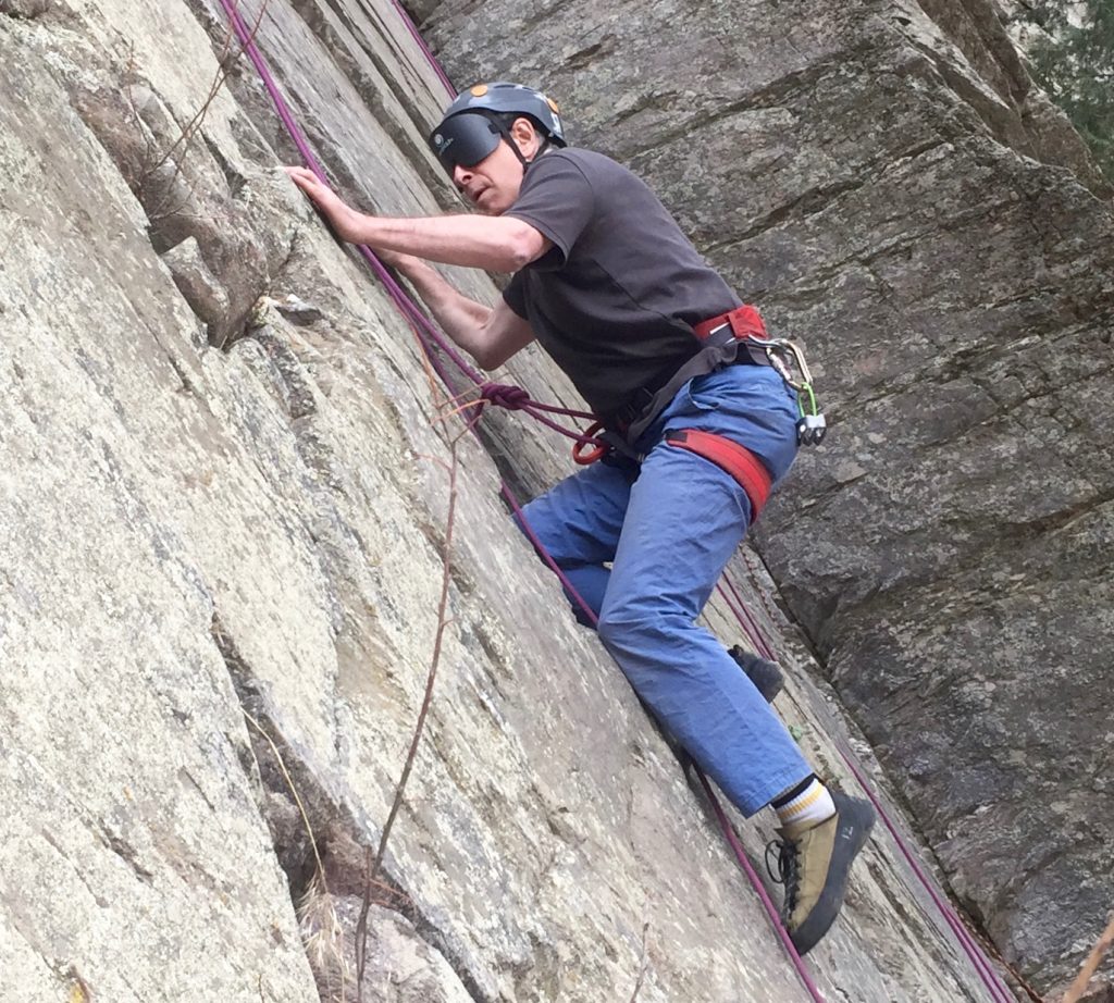 profile of Peter climbing up a rock face