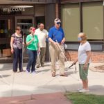 seven people go out the front door with white canes