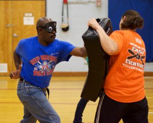 a man attacks the pad held by his instructor