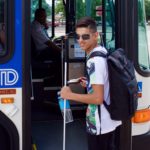 Smiling young man prepares to board the RTD bus