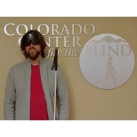 Graham standing in front of the CCB logo in the front lobby