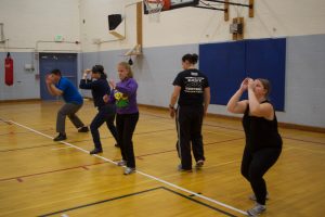 Rachael has the Martial Arts class practice a crouched defensive move