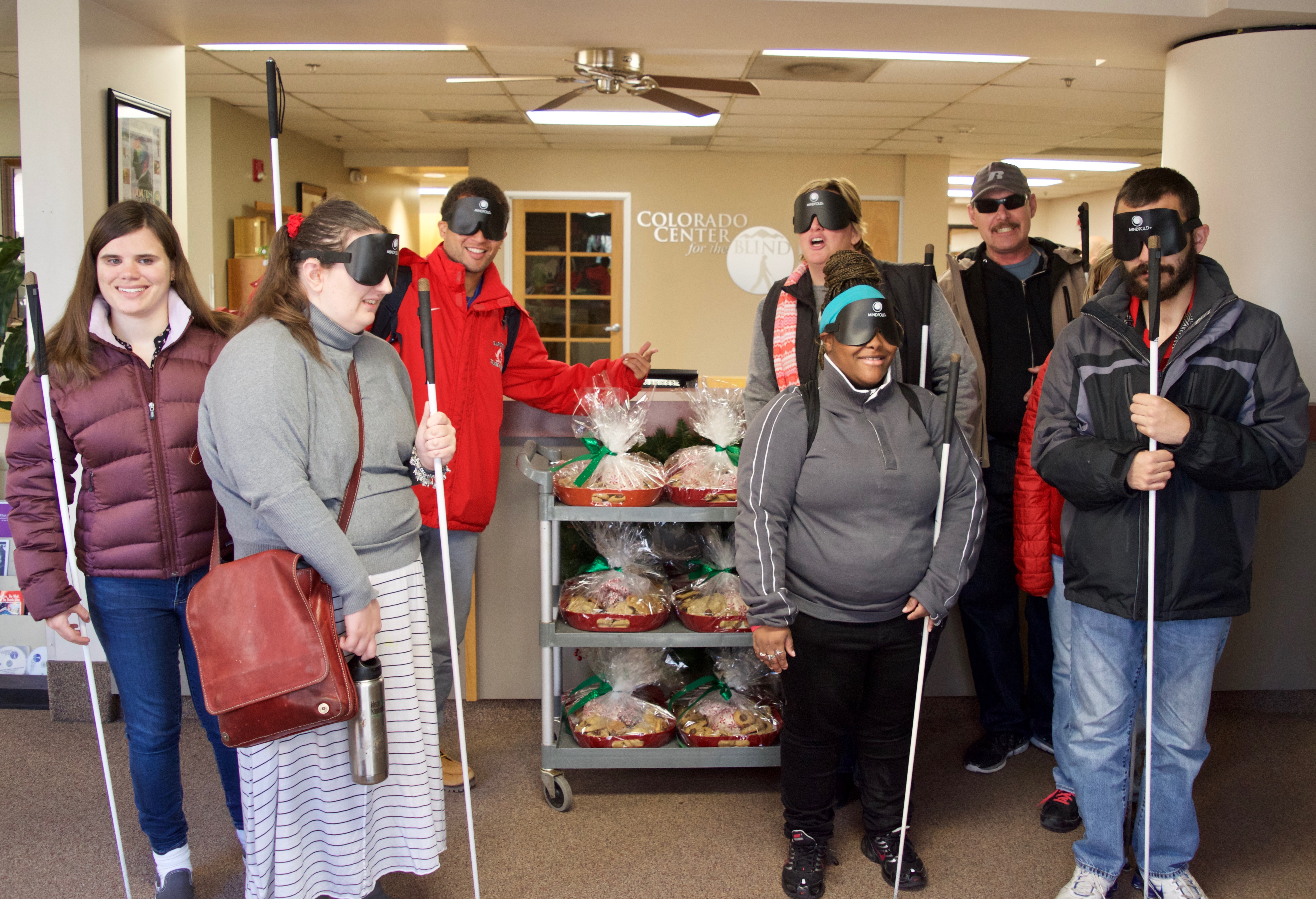 A group of CCB students pose around a cart with six large trays of goodies to give out