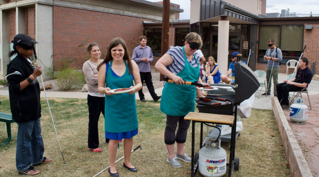 staff and students on the front patio grilling and enjoying the day