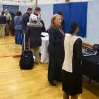 tables in the exhibit area are thronged with job seekers and students