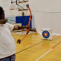 Jesse takes aim with his bow in Archery Class