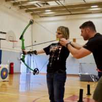 Joy works with Josh on aiming her Bow