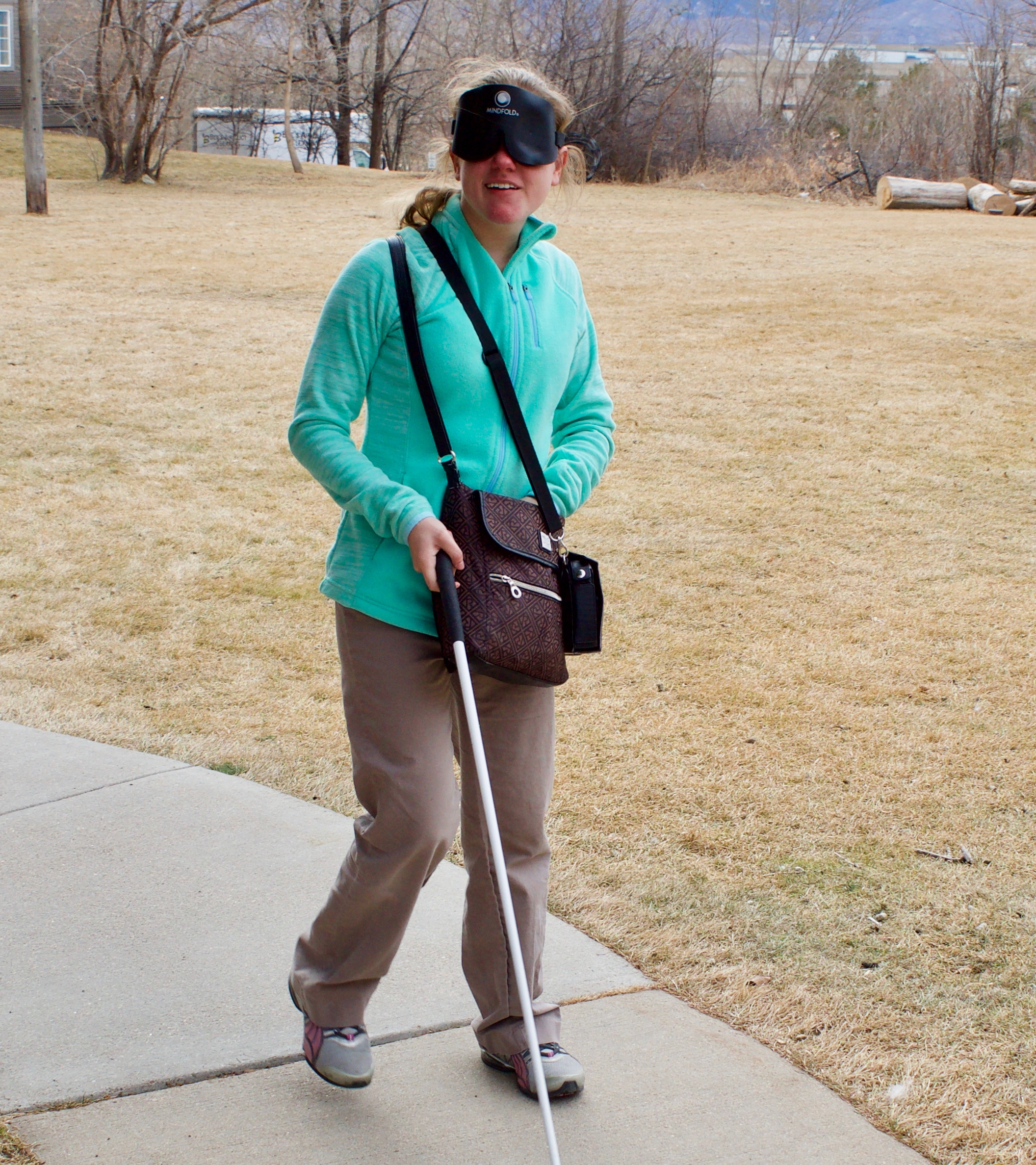 Julie M. traveling with her cane and sleepshades