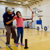 An NSCD Instructor instructs Serena on how to draw back on the Bow