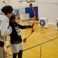 Suzi takes aim with her bow in Archery Class