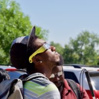 Leon wears eclipse glasses and takes a look as the eclipse gets started