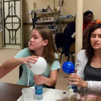 Maggie and Lauren experiment with chemically inflating balloons
