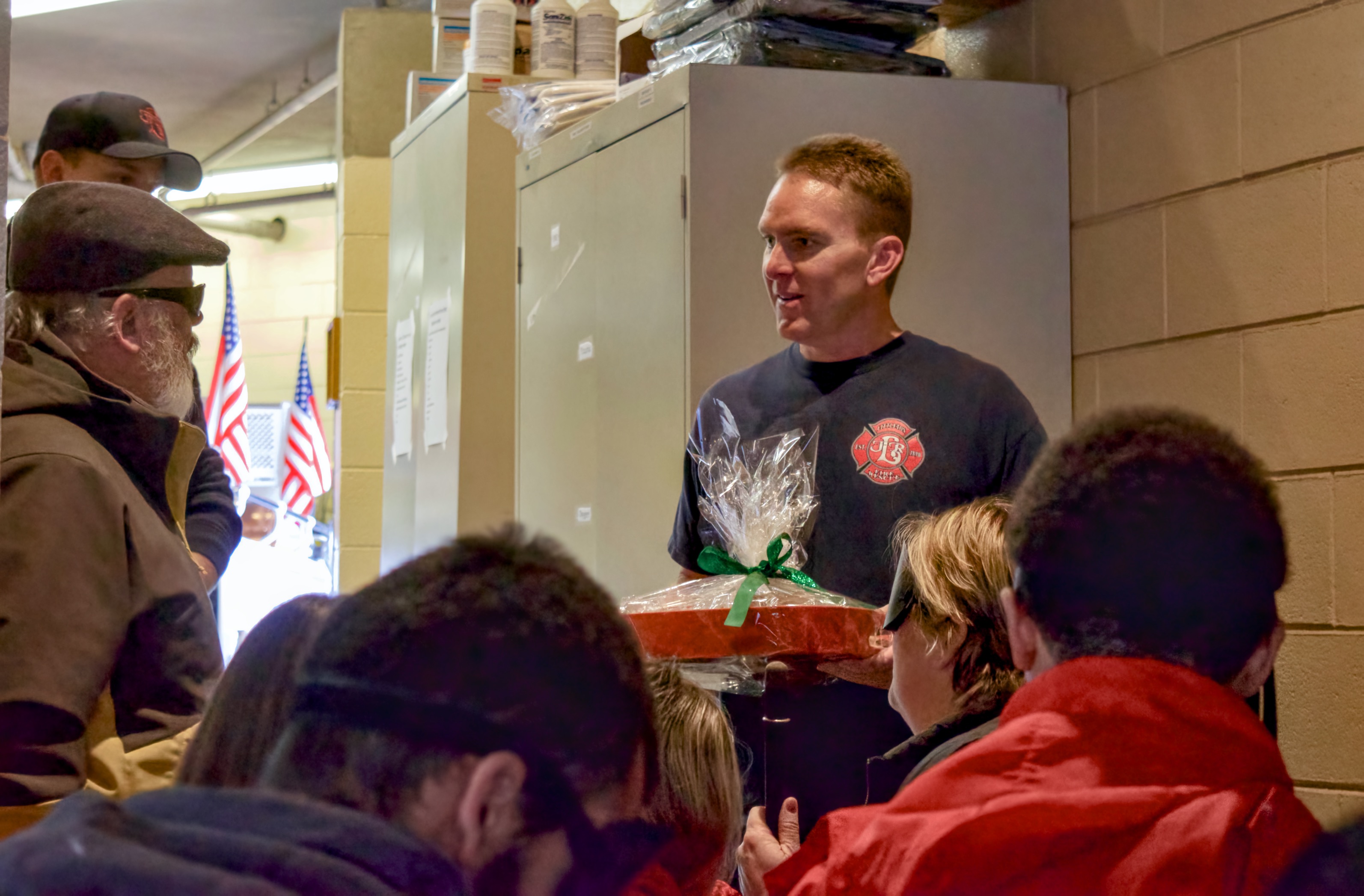 A Fire Fighter holds a tray of goodies presented by a group of CCB students
