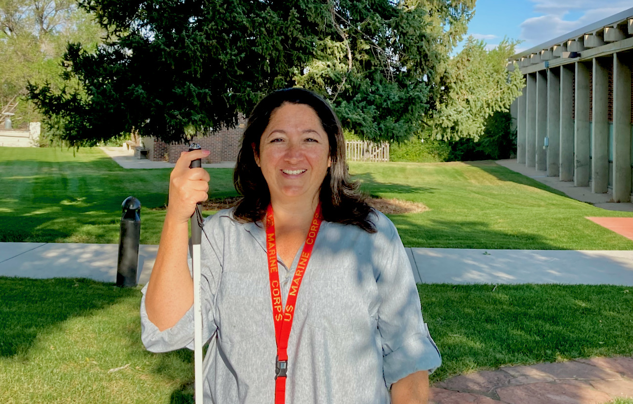 A smiling woman wearing a U.S. Marine lanyard