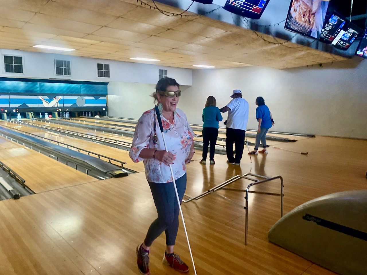 Brenda walks back after her throw, grinning from ear-to-ear. In the background Andrew , Duncan Larsen, and Saray are all bowling.