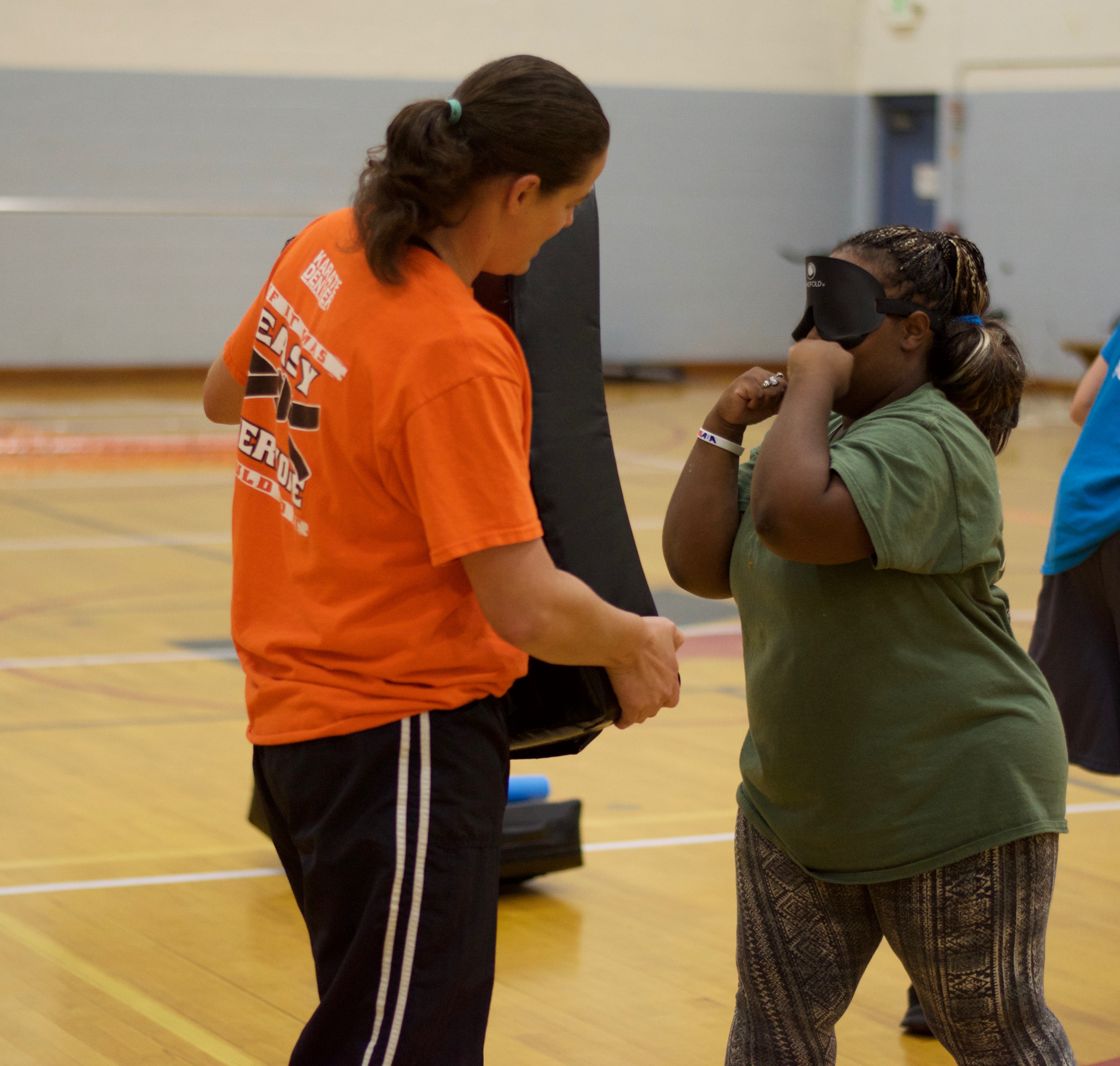 a young woman in sleepshades takes a fighting stance