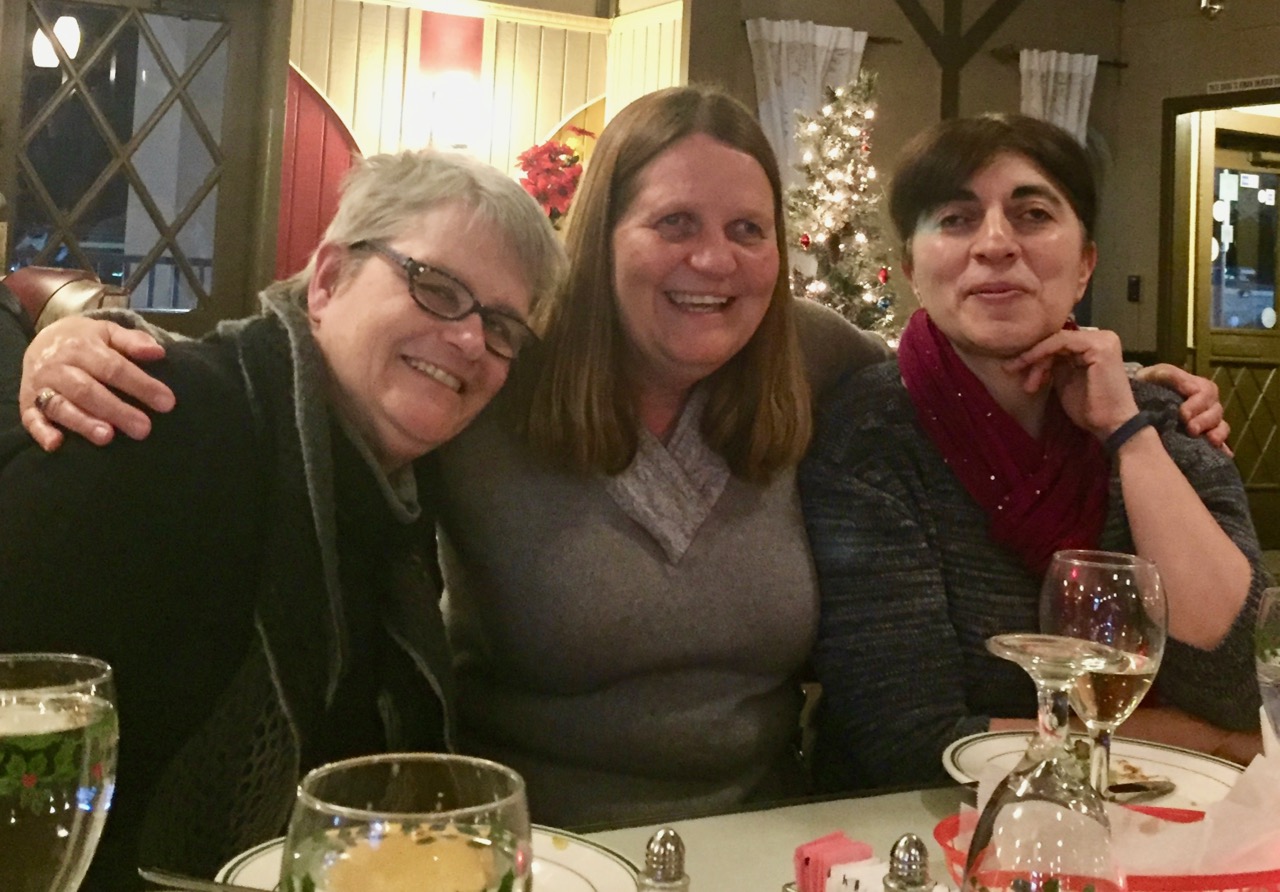 Cathy, Julie and Anahit smiling across the table at a local restaurant