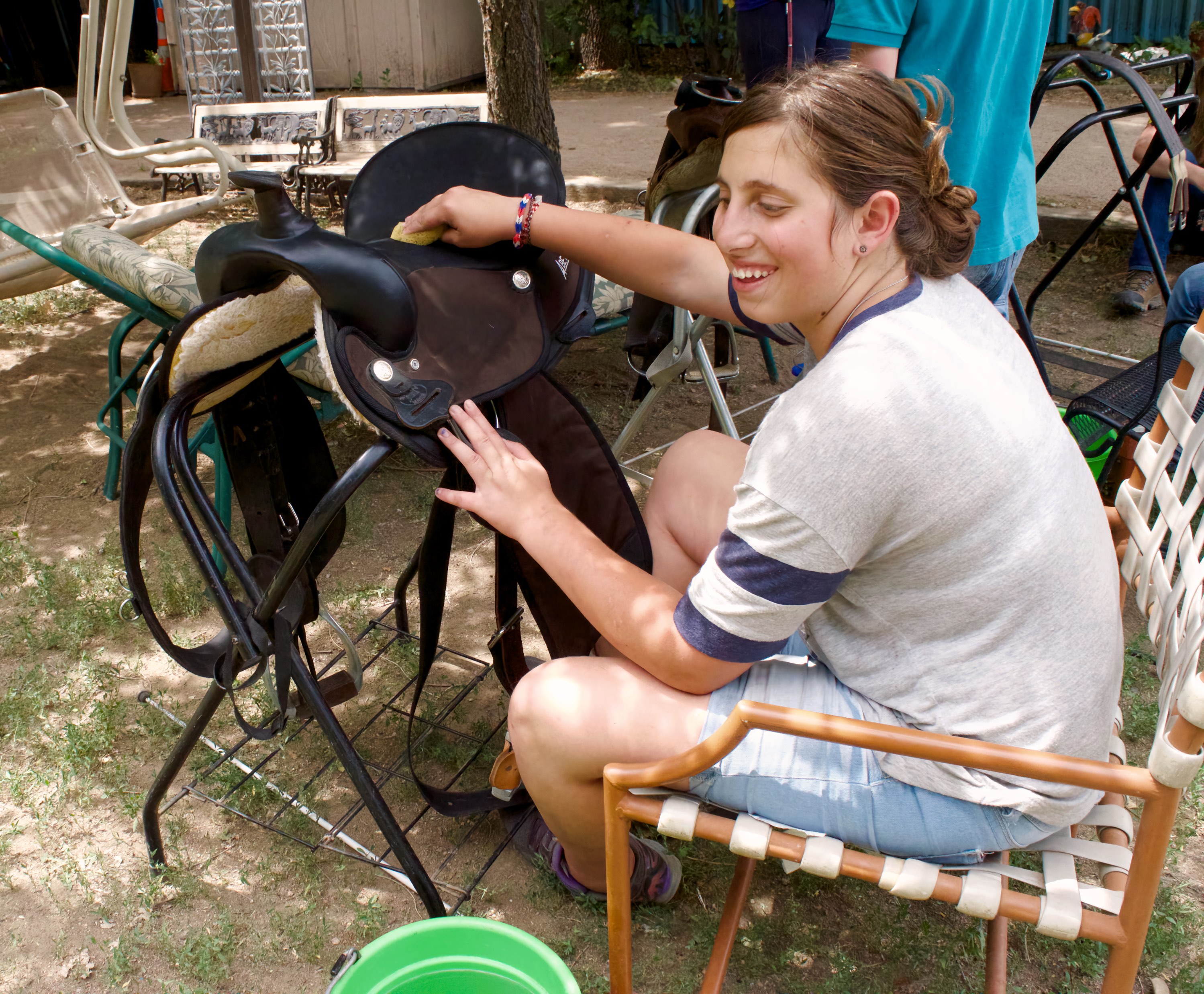 Christina works on cleaning and polishing a saddle