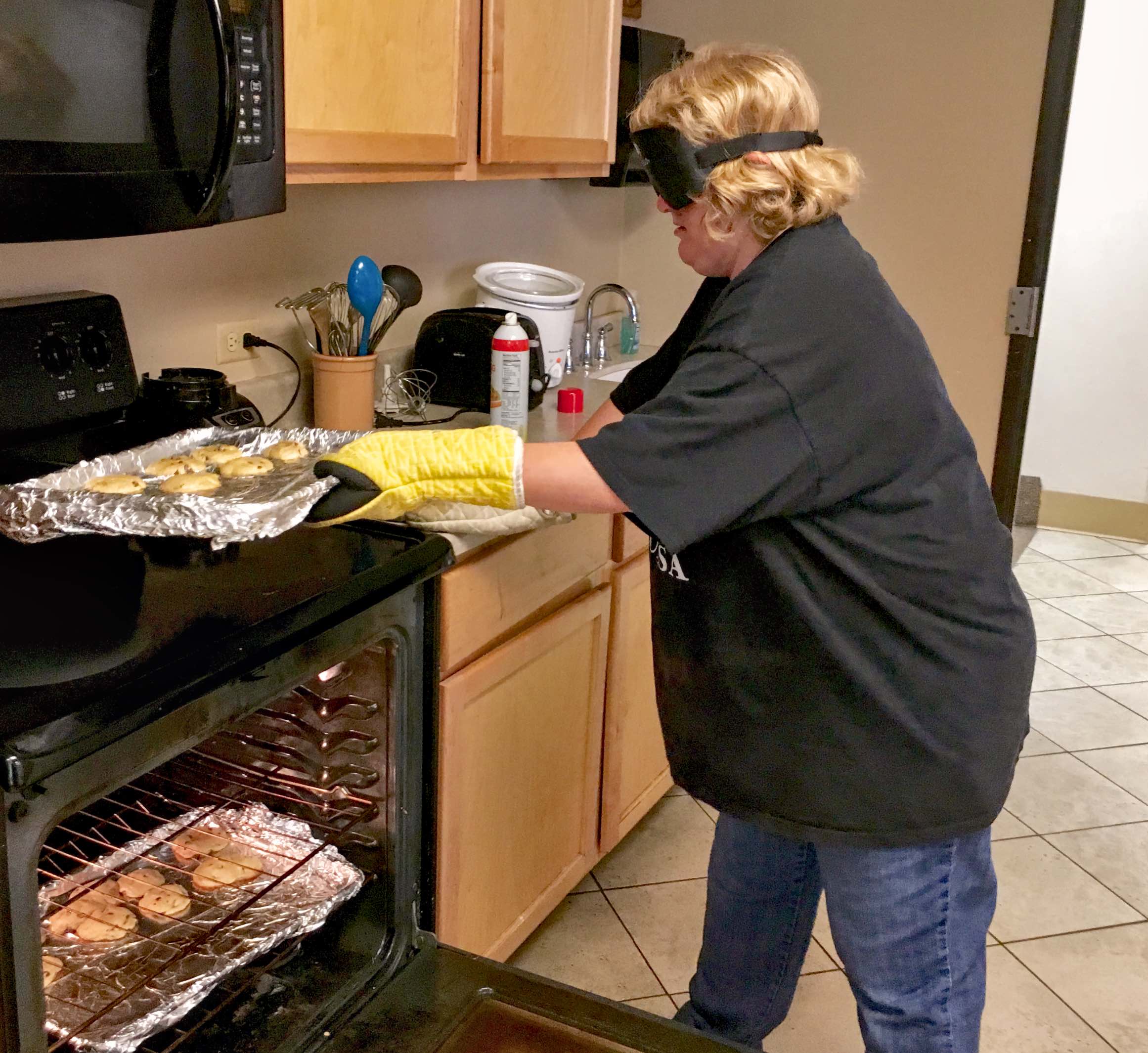 Woman takes cookies out of a hot oven
