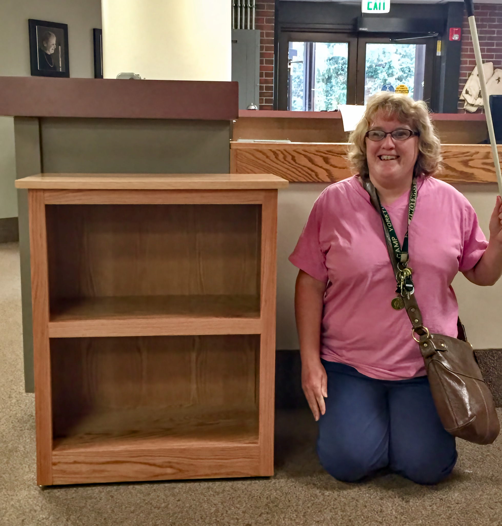Student stands beside her handsome 3-shelf bookshelf
