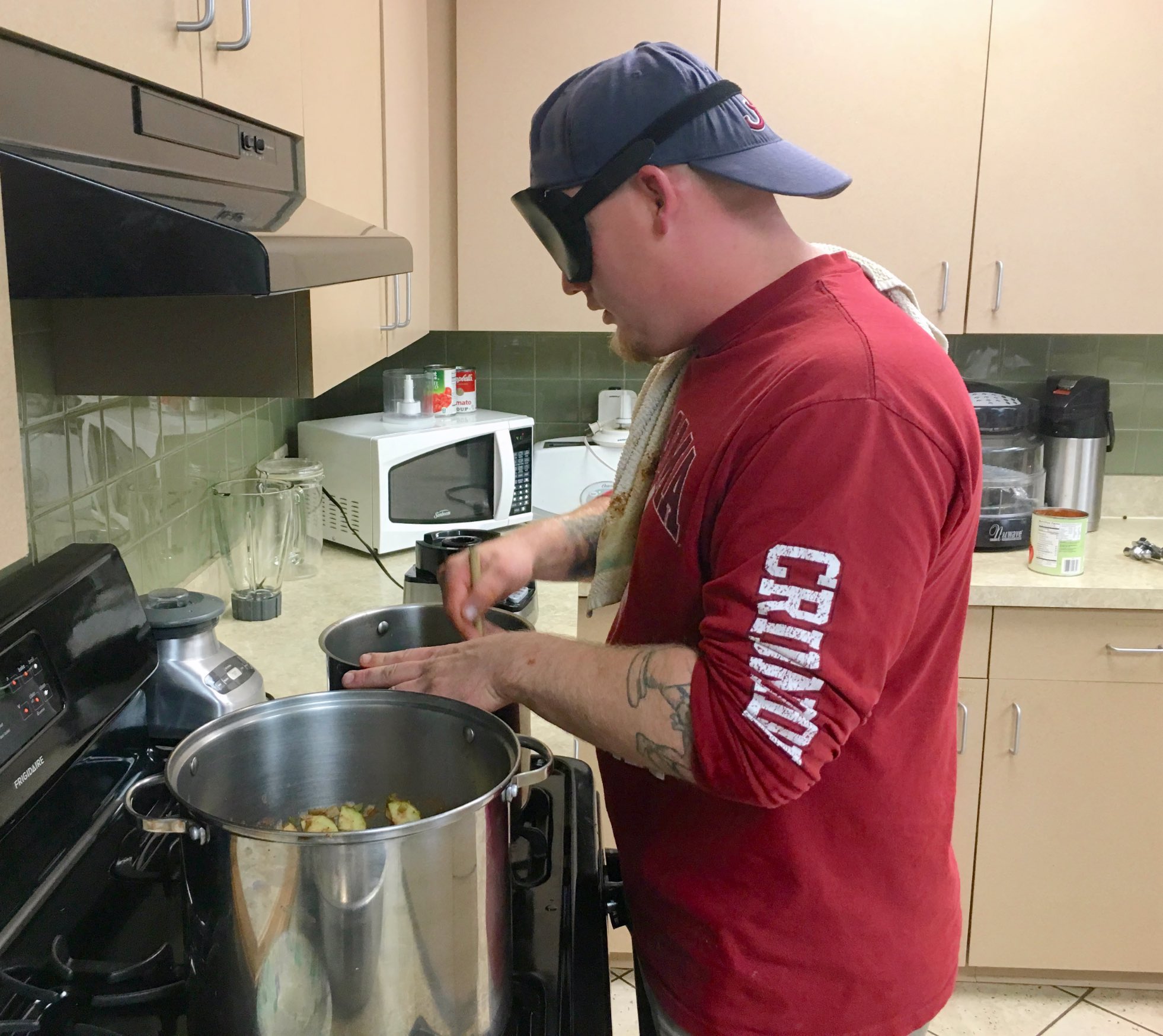 Daniel working two large pots on the stove