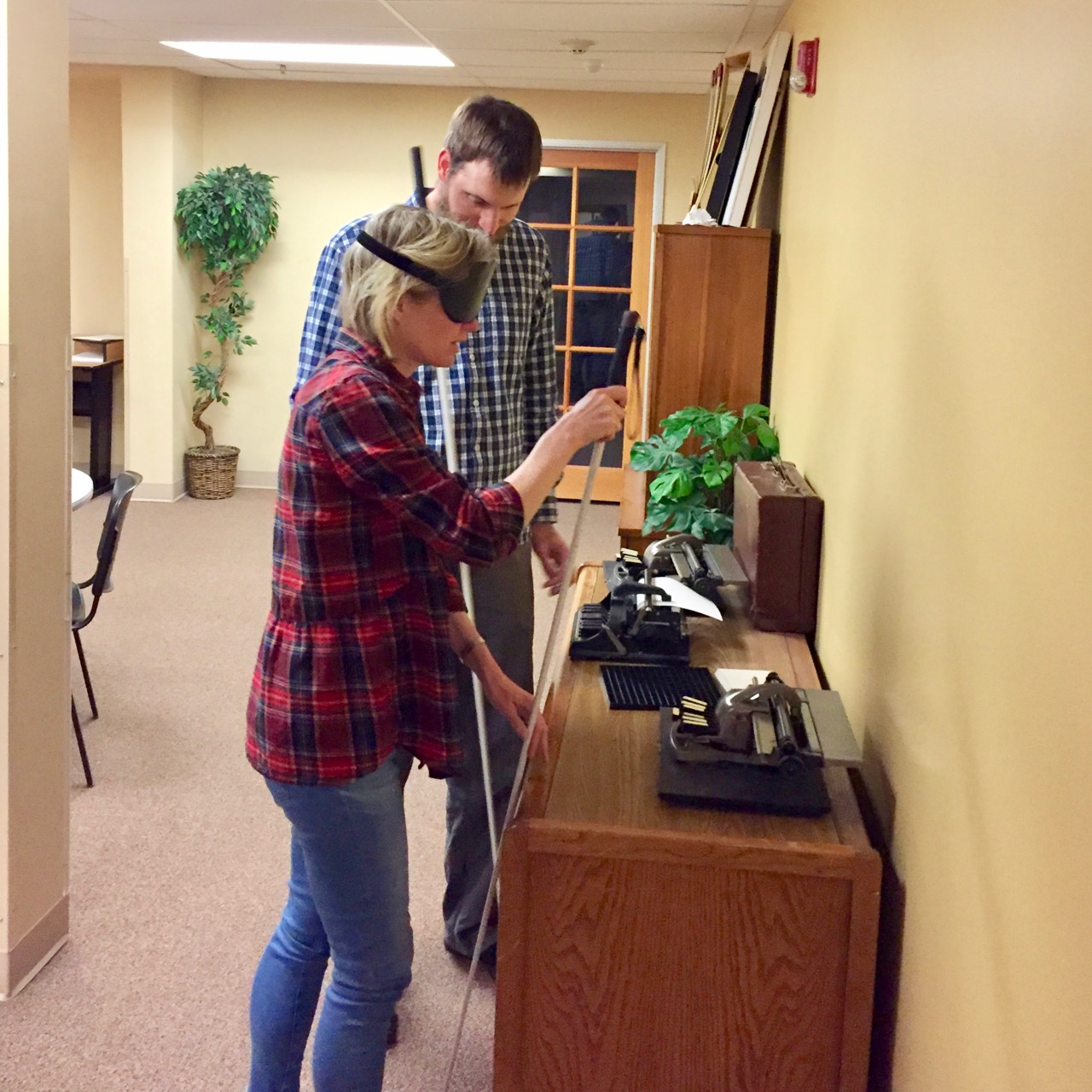 David does a little Structured Discovery with Kirsten in the travel lobby exploring antique Braille writers on a display