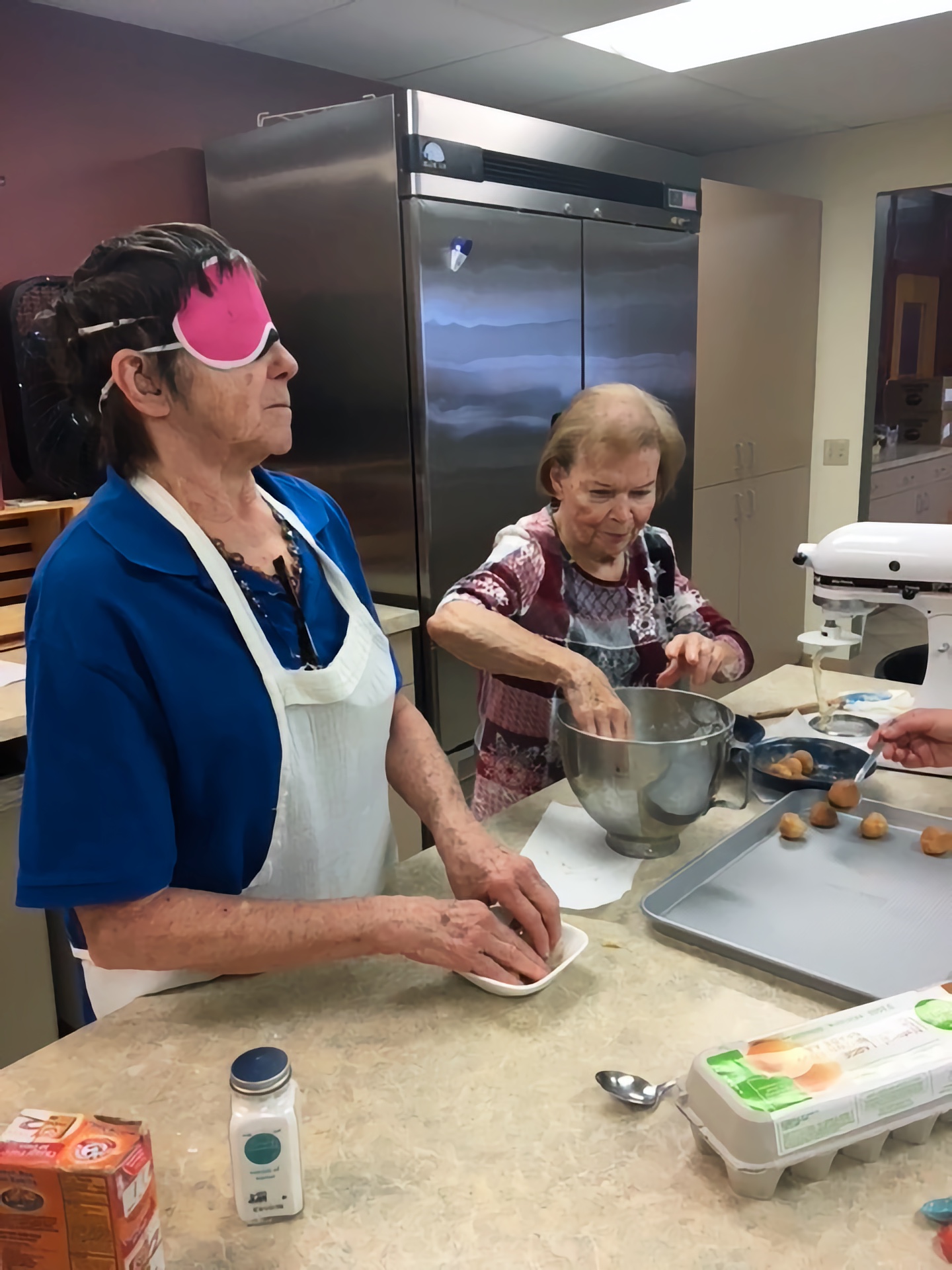 Dee rolls dough in sugar and cinnamon for home made cookies. Mary Ann rolls the dough into balls