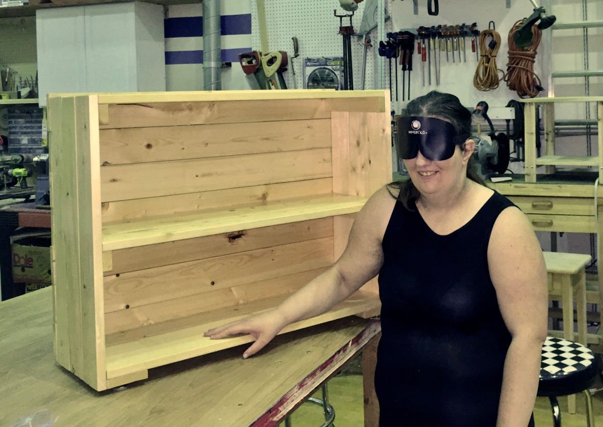 Ellen beside her bookshelf in the shop