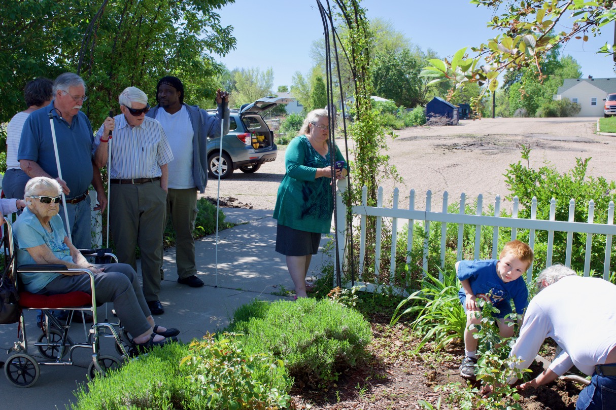 Family and friends gather as Isaac and Isaac plant the rose