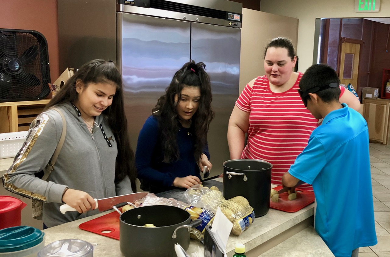 Brittany not only volunteered on FAST Saturday, she also volunteered her best-ever mashed potato recipe. Here she has three high school students slicing the spuds.