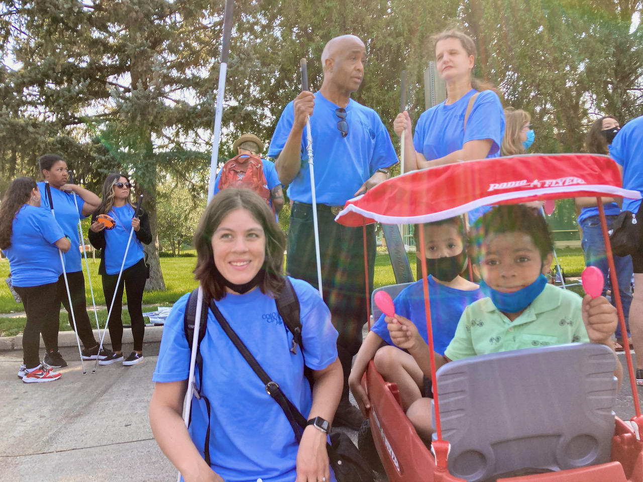 Jackson gives his Maracas a two-fisted shake as he and Mason prepare to start the Parade. Jackson’s mom Chris kneels beside the boys, and Mason’s parents, Jen and Dishon stand behind them.