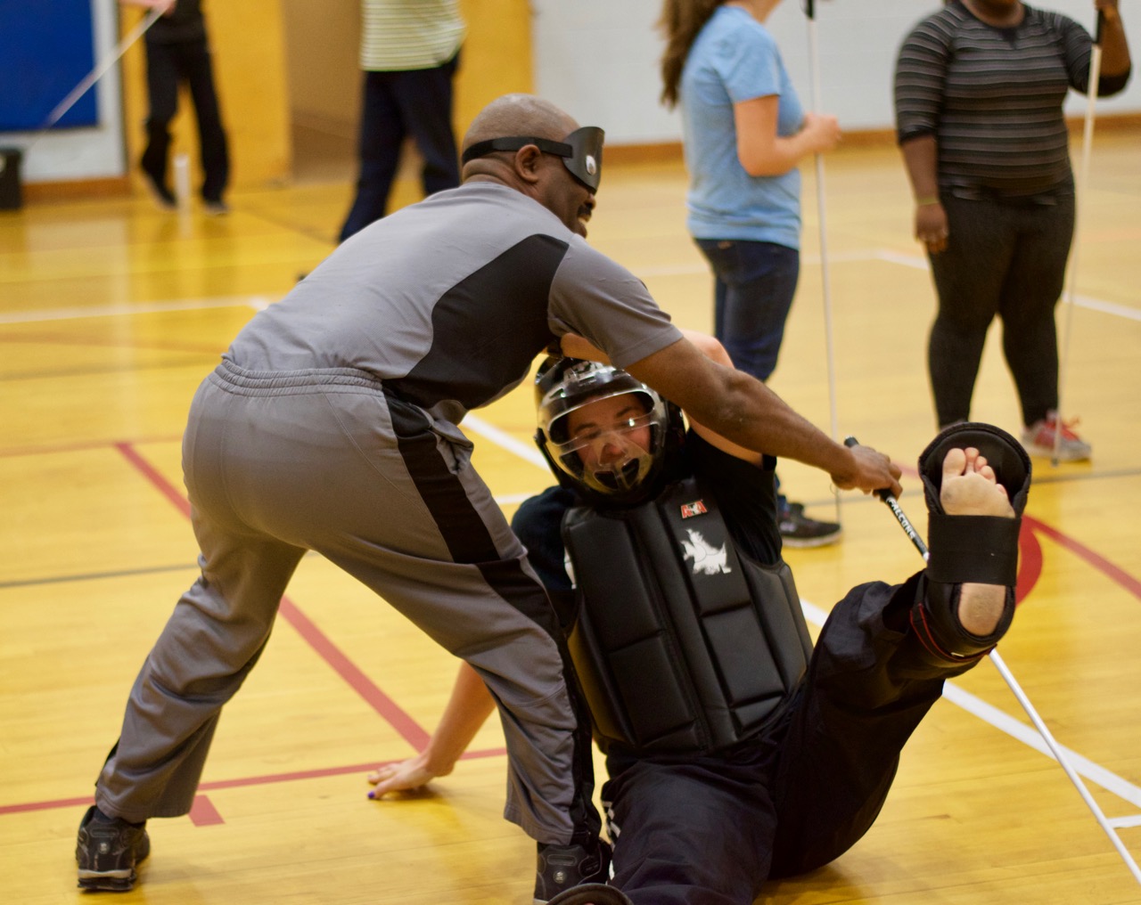 Jimmi throws Rachael to the ground while keeping hold of his cane