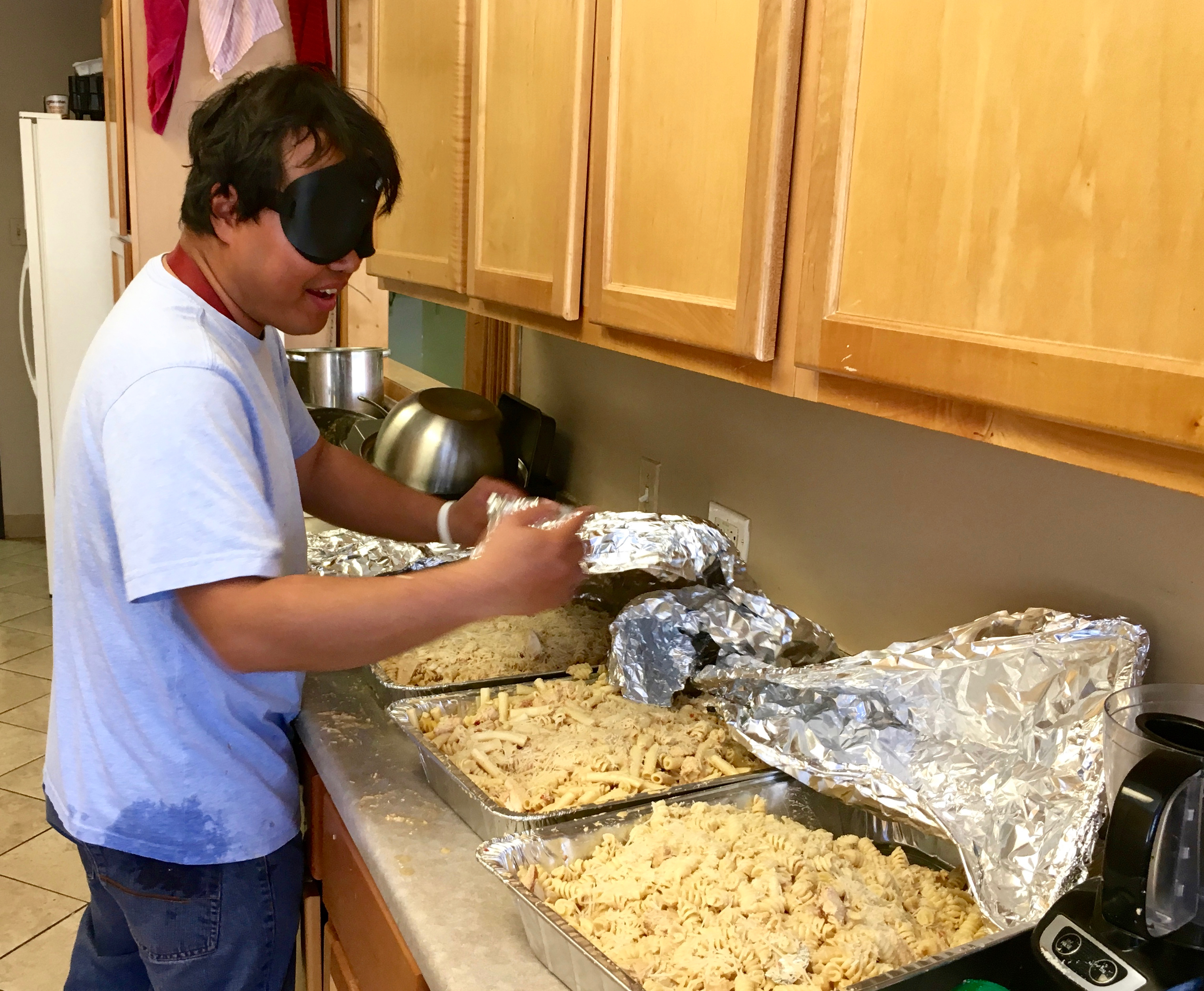 Joey with four hotel pans of pasta