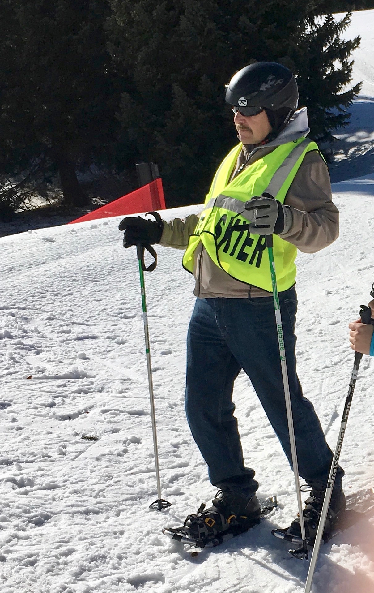 John on the slope with ski poles and snowshoes