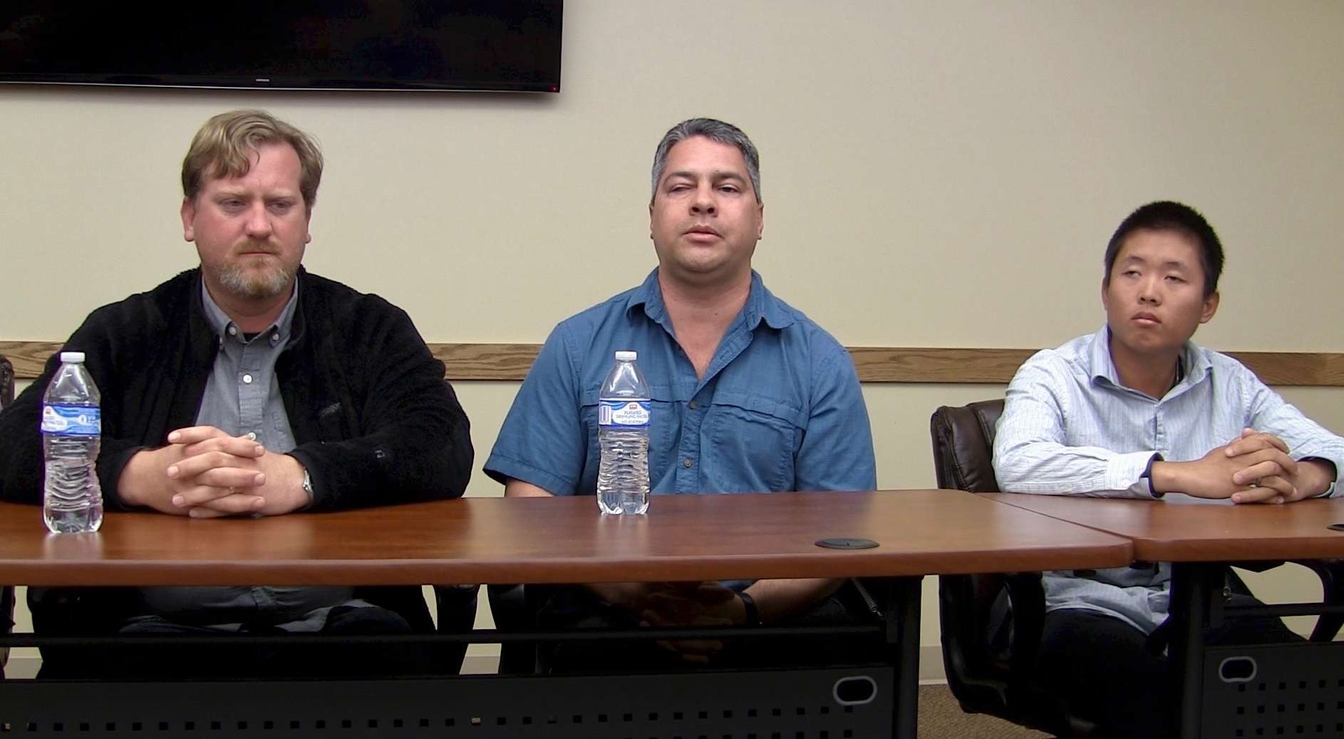 Three men seated at a long table, facing a room of listeners. Left to right are Derek Williamson, Dr. Eddie Bell and Colin Wong, part of a philosophy class on Wednesday.