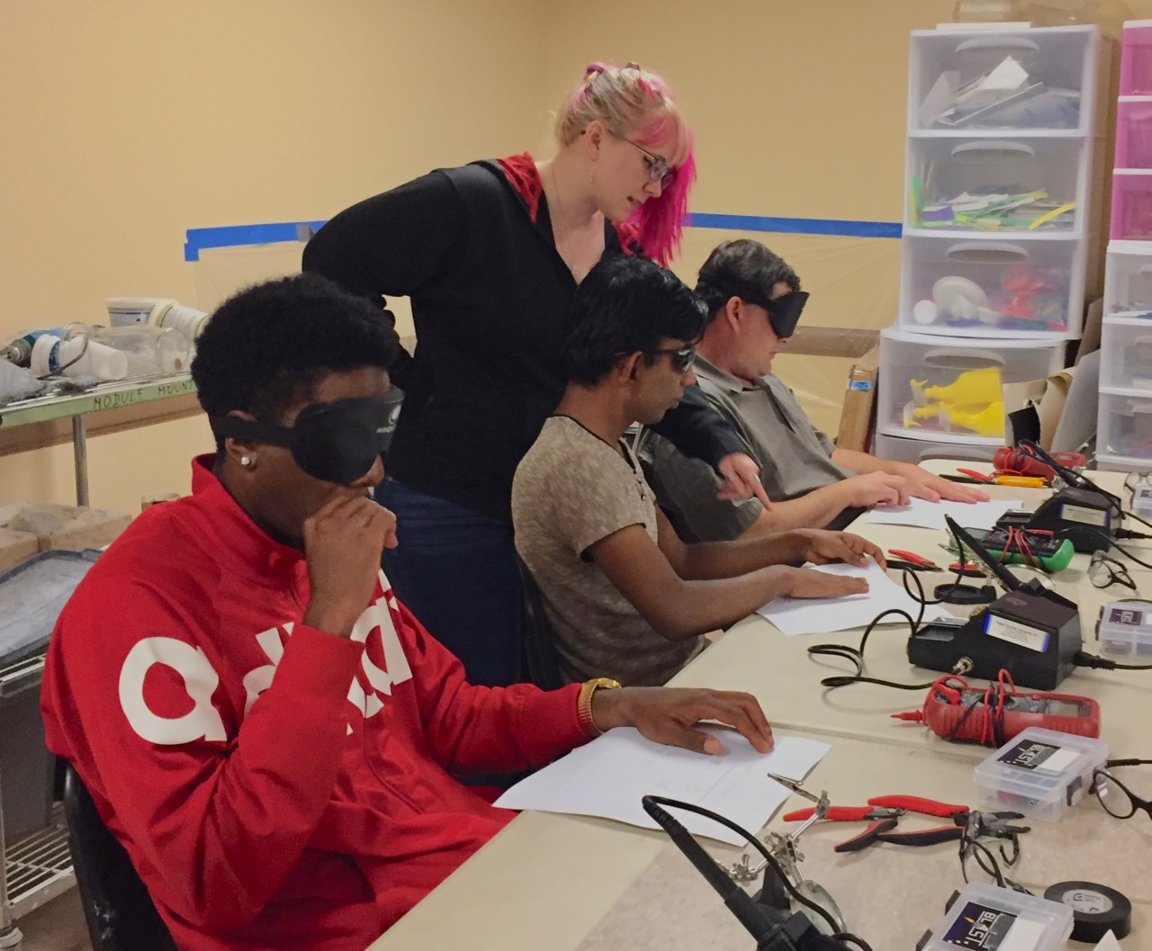 Leon, Jay, and J.D. look at a tactile schematic diagram while a volunteer points out specific features