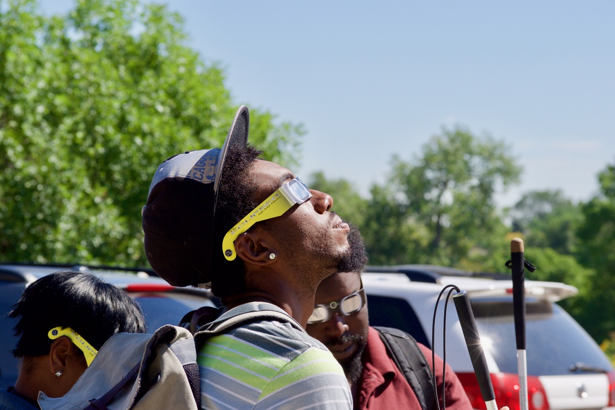 Leon wears eclipse glasses and takes a look as the eclipse gets started