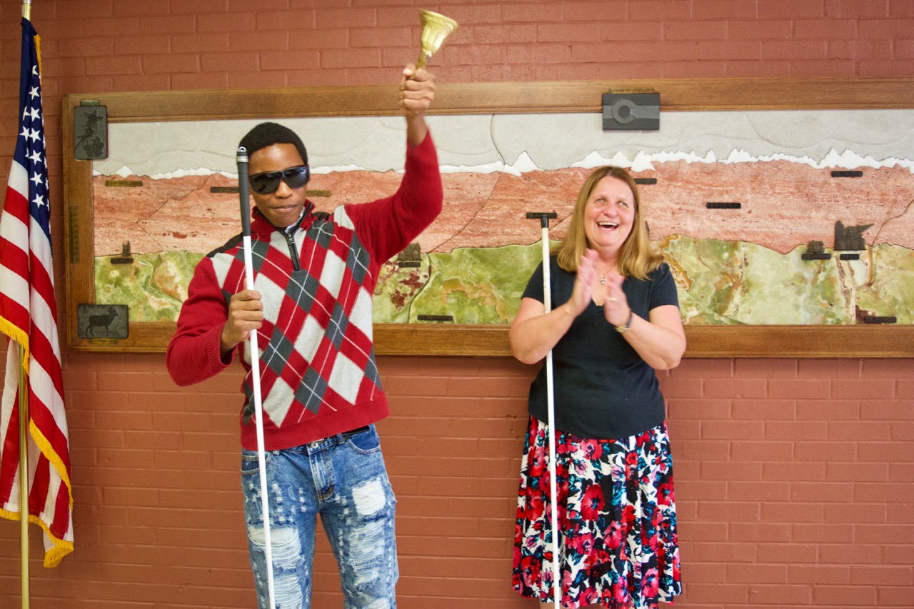 Loren M. ringing his “Bell of Freedom” at graduation with Julie clapping